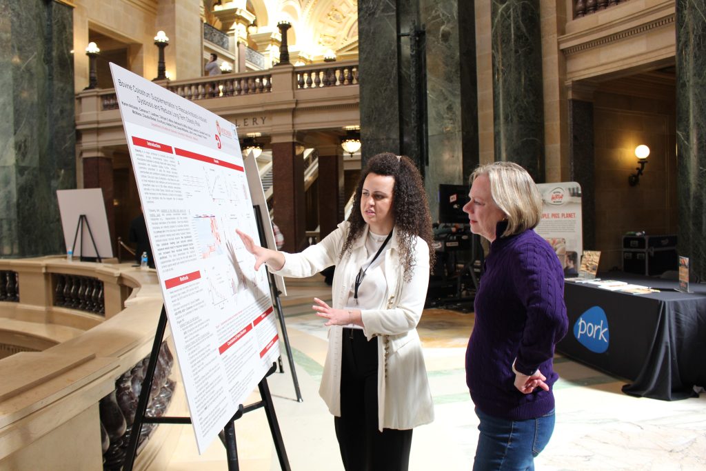 person explaining research poster to another person