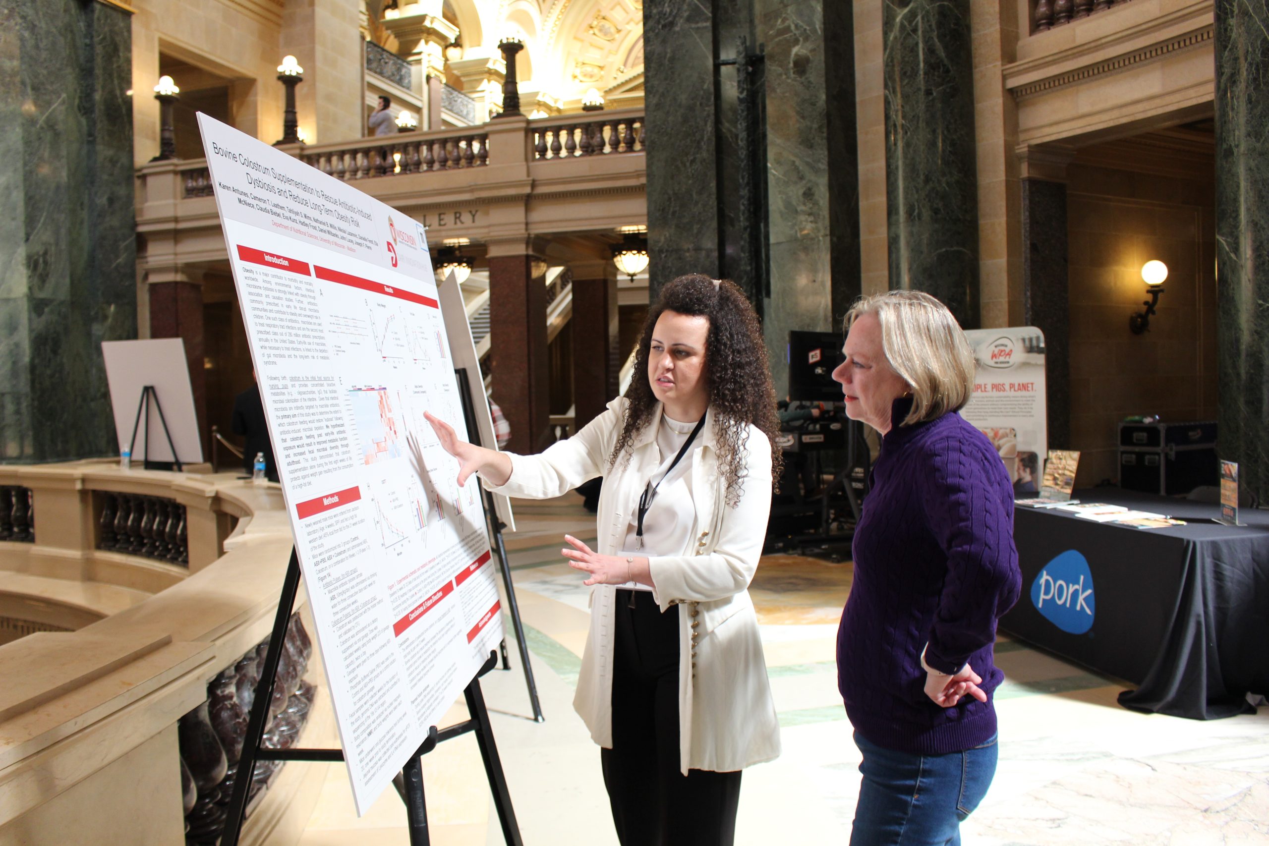 person explaining research poster to another person